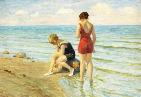 Zwei junge Frauen in einem roten und einem blauen Badeanzug am Strand 1917