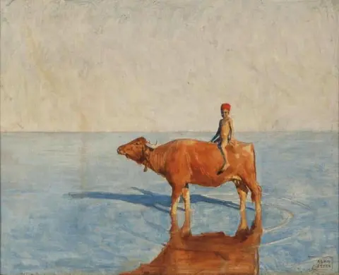A Boy Riding A Water Buffalo